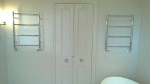 Double doors into a bathroom with heated towel rails