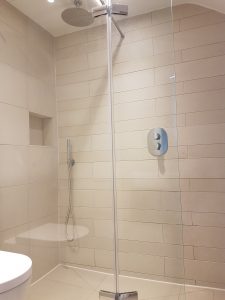 A bathroom picture shower a wet room with textured porcelain wall tiles and impey aqua dec shower tray